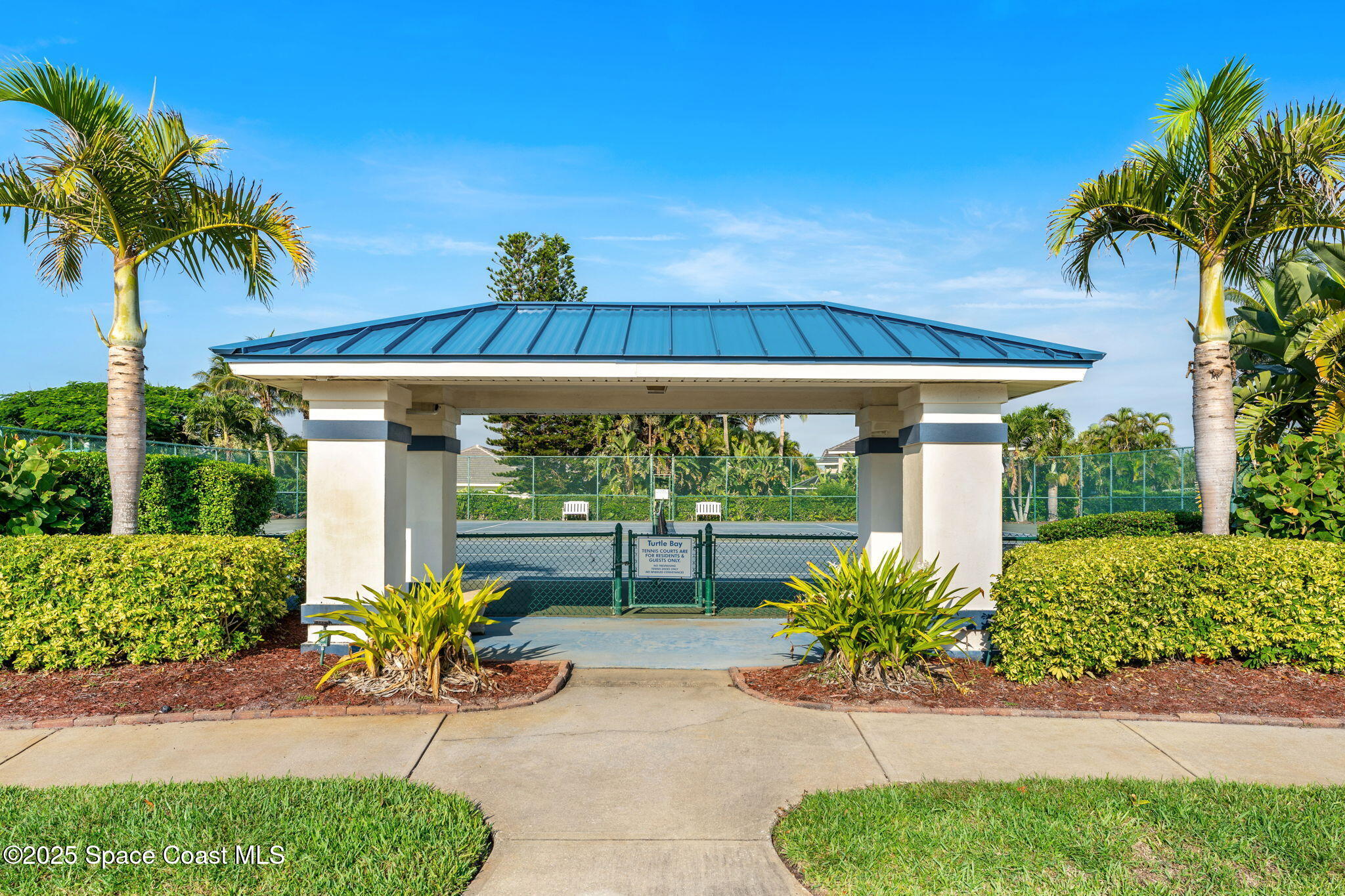 227 Loggerhead Drive Melbourne Beach, FL 32951 - Photo 42 of 52 a view of a patio with a table and chairs under an umbrella with potted plants
