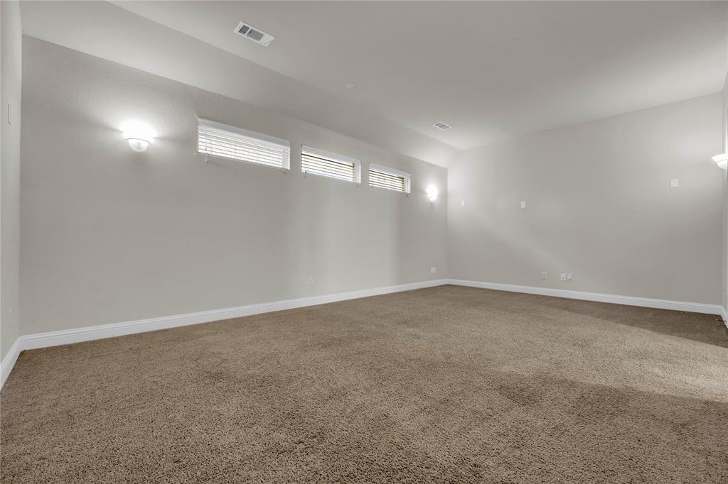 1011 Prairie Ridge Lane Arlington, TX 76005 - Photo 23 of 32 Spacious room featuring neutral carpeting, light gray walls, white baseboards, and triple horizontal windows with blinds