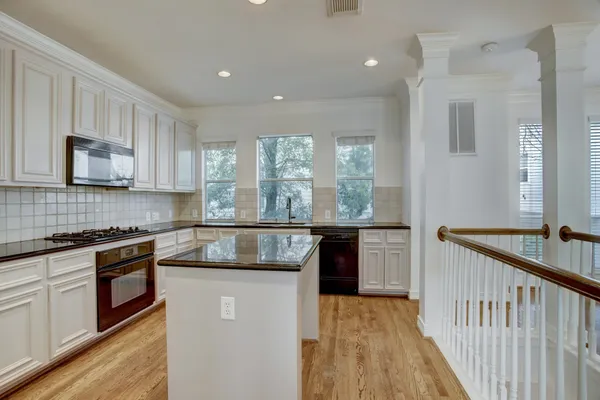 a kitchen with stainless steel appliances granite countertop a stove a sink and a microwave