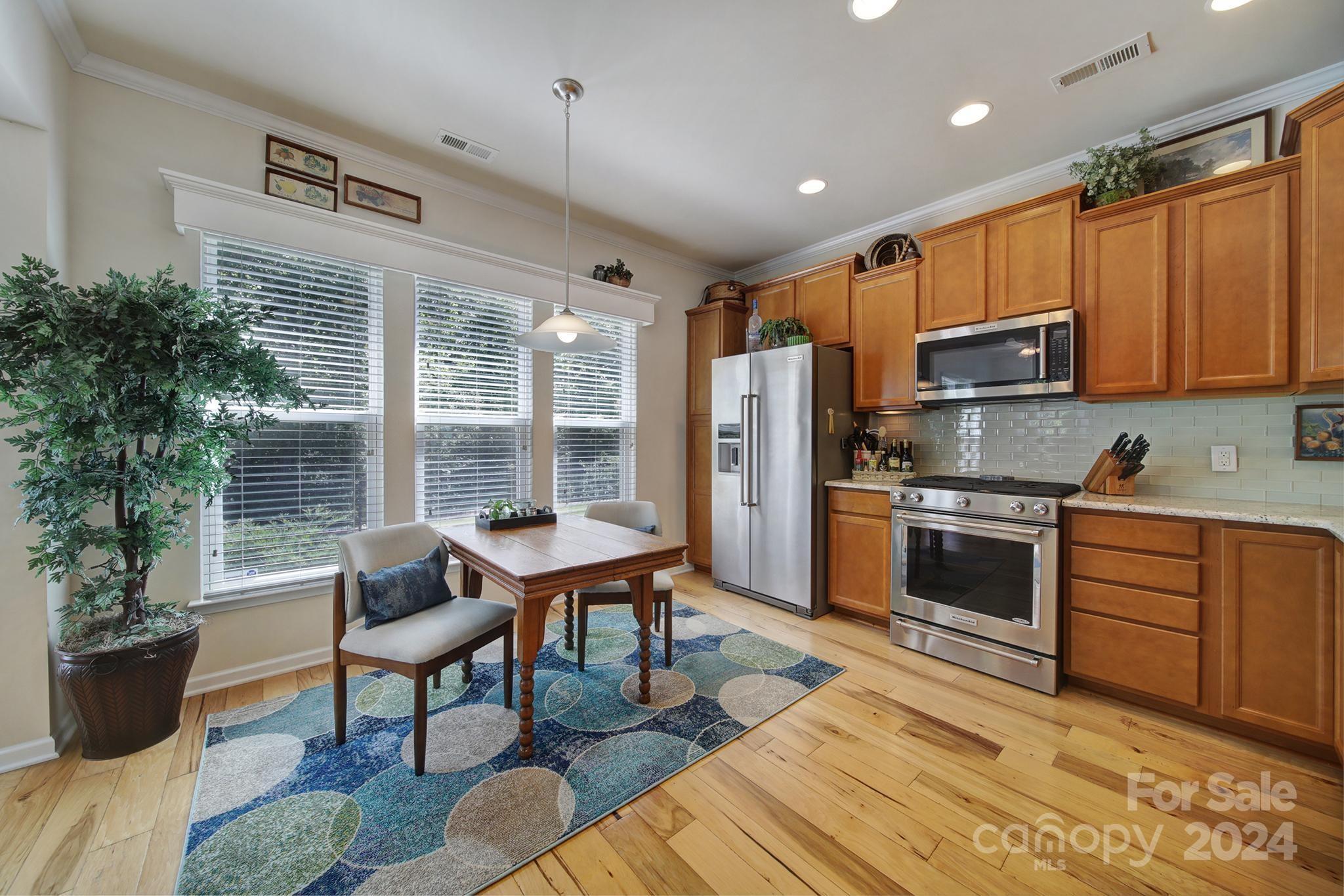 3055 Everett Lane Fort Mill, SC 29707 - Photo 12 of 40 a kitchen with stainless steel appliances kitchen island granite countertop a refrigerator and wooden cabinets