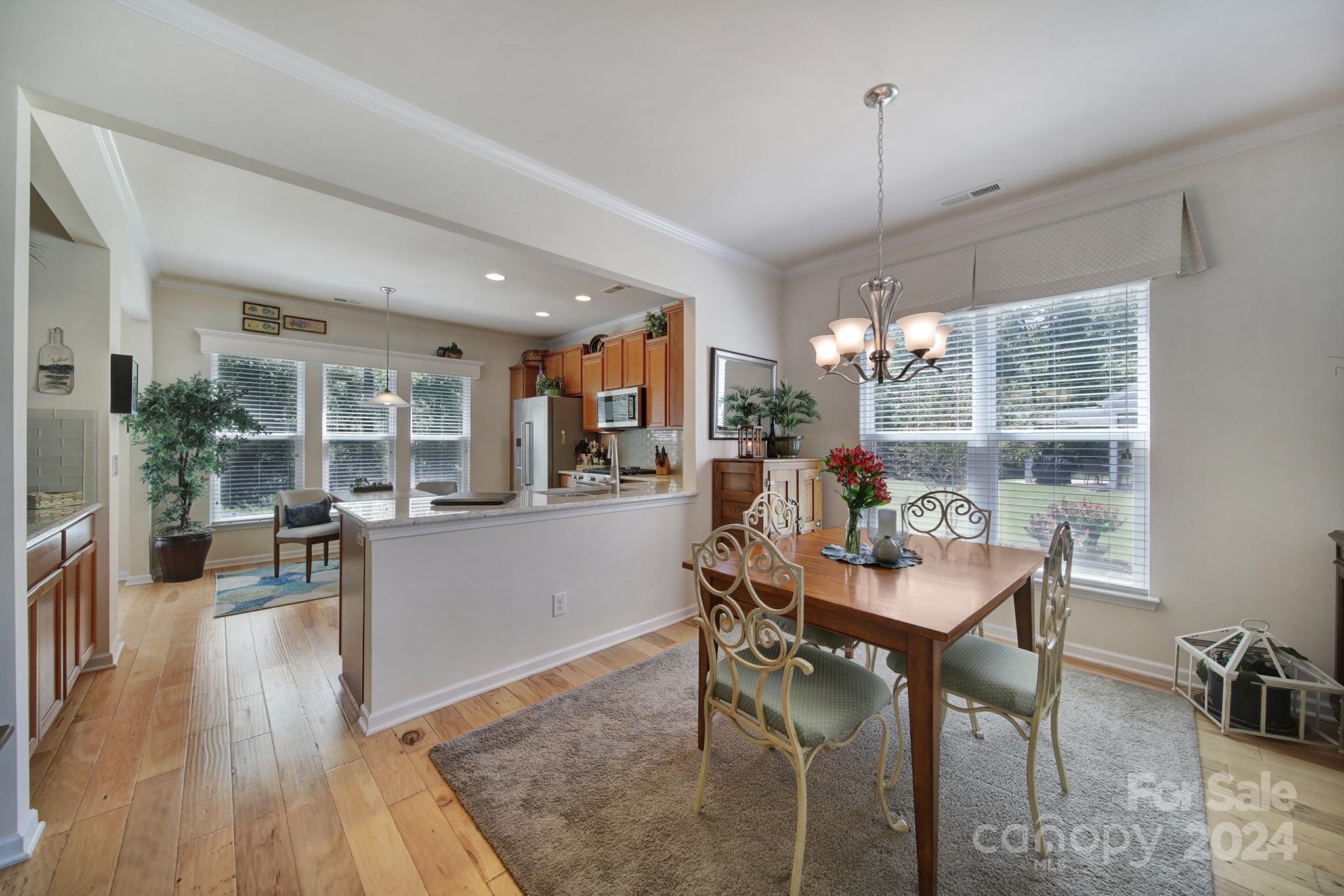 3055 Everett Lane Fort Mill, SC 29707 - Photo 10 of 40 a dining room with furniture a chandelier and wooden floor