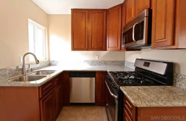 a kitchen with stainless steel appliances granite countertop a sink stove and microwave