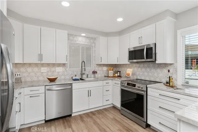 a kitchen with a sink stove and white cabinets