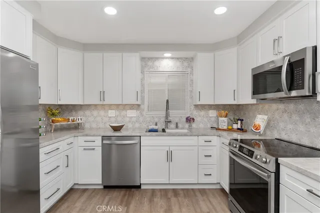 a kitchen with white cabinets stainless steel appliances and sink