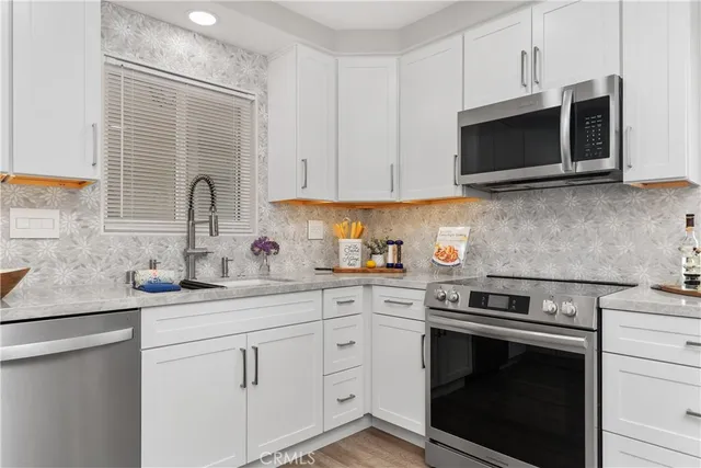 a kitchen with stainless steel appliances granite countertop a sink stove and microwave