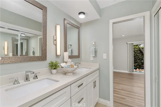 a bathroom with double vanity sinks and a mirror