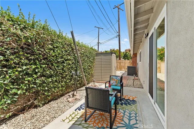 a balcony with chairs and with potted plants