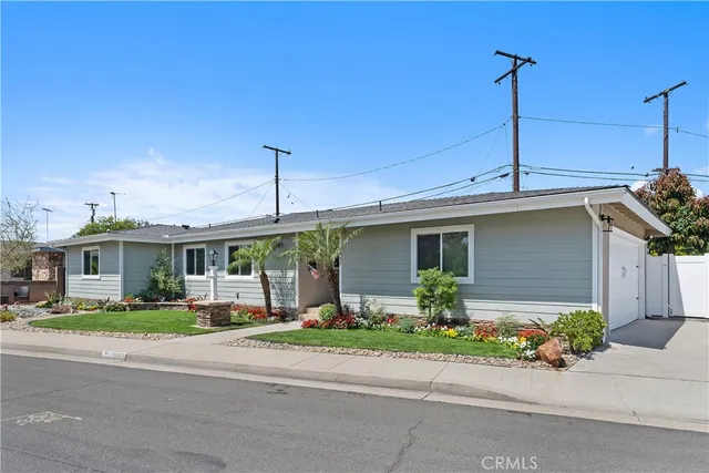 a front view of a house with a garden and plants