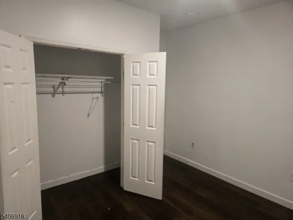 an empty room with wooden floor and closet