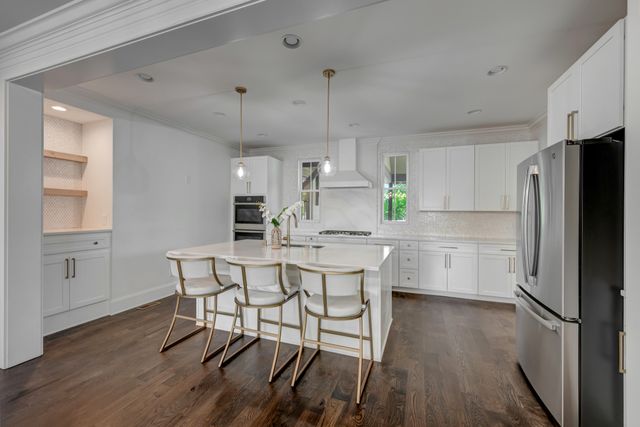 a kitchen with a table chairs refrigerator and microwave