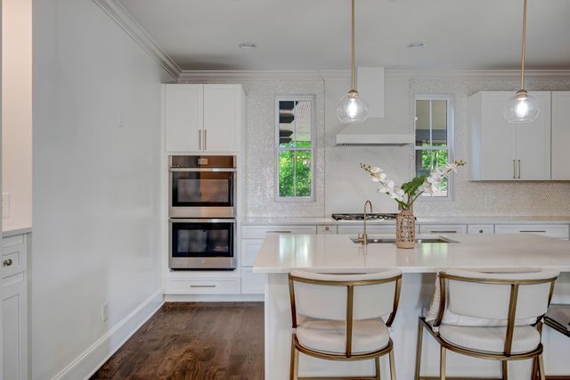 a kitchen with a table chairs microwave and cabinets