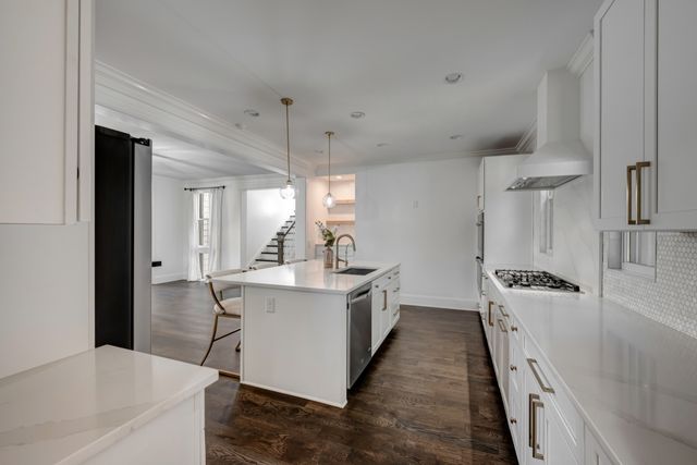 a kitchen with white cabinets and sink
