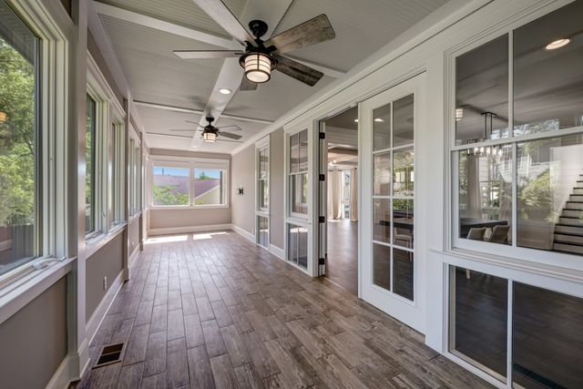 a view of a hallway with wooden floor and front door
