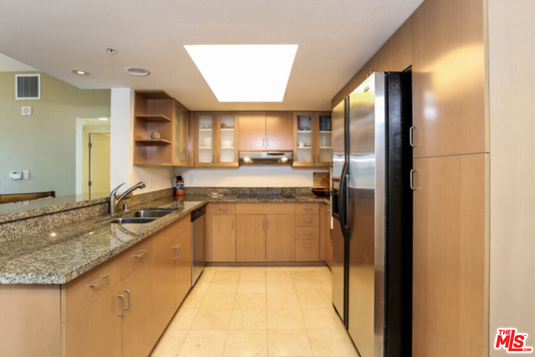 13700 Marina Pointe Drive, Unit 618 Marina del Rey, CA 90292 - Photo 8 of 22 a large kitchen with granite countertop a sink and a refrigerator