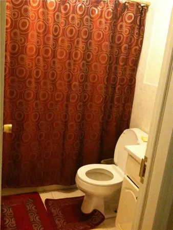 a bathroom with a toilet and a shower curtain