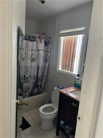 a bathroom with a toilet and a shower curtain