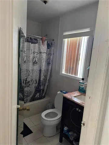 a bathroom with a toilet and a shower curtain