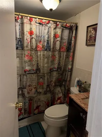 a bathroom with a toilet and a shower curtain
