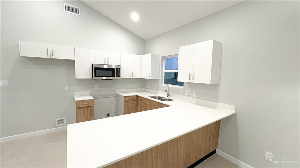 612 Oriole Road Weslaco, TX 78596 - Photo 7 of 16 a kitchen with granite countertop a sink stove and microwave