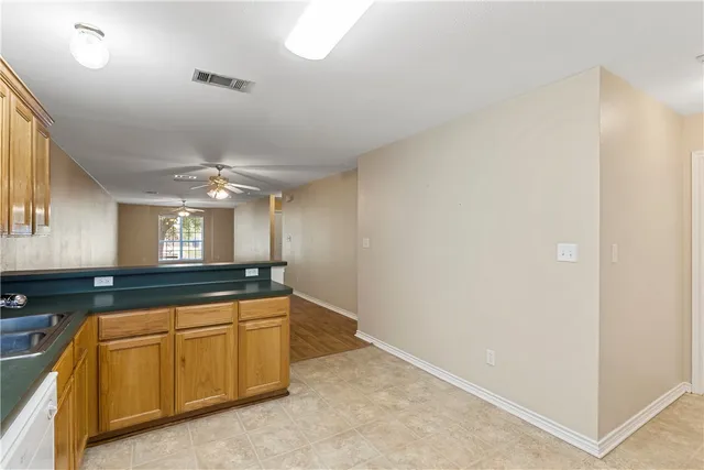 a kitchen with granite countertop a sink and white cabinets