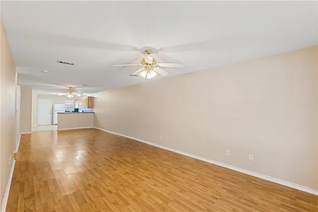 a view of a livingroom with a kitchen space with wooden floor