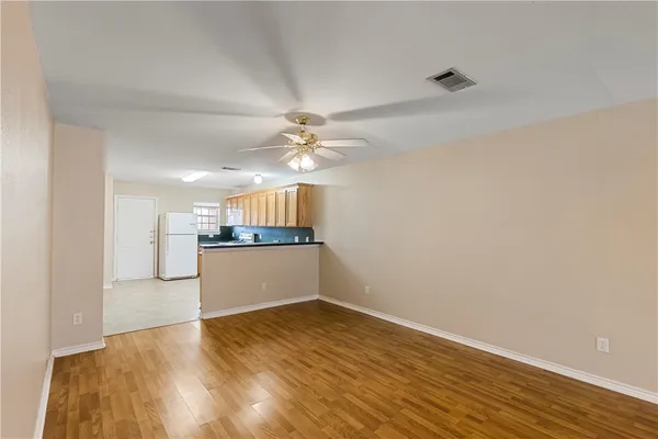 a view of a kitchen with wooden floor and a ceiling fan