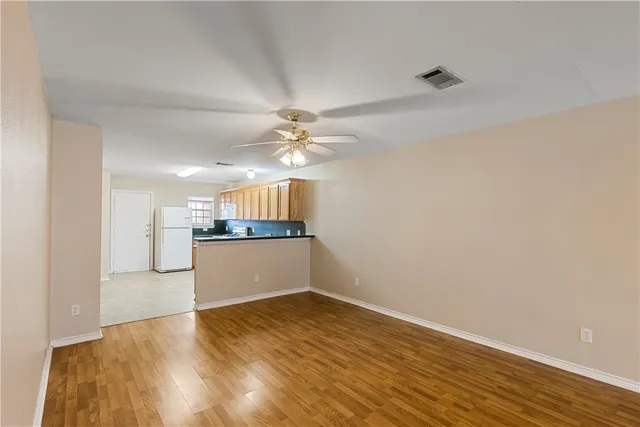 a view of a kitchen with wooden floor and a ceiling fan