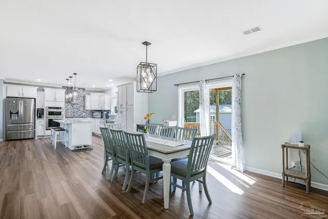 a view of a dining room with furniture wooden floor and chandelier