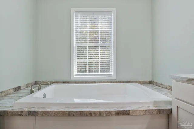 a bedroom with a bed and a flat tv screen on dresser