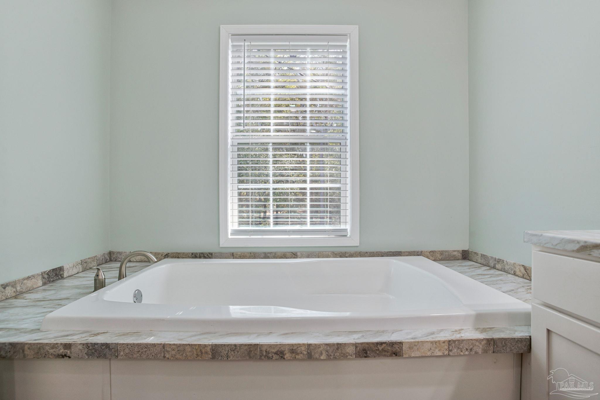 4955 Blue Ribbon Drive Milton, FL 32583 - Photo 20 of 43 a bathroom with bathtub and window