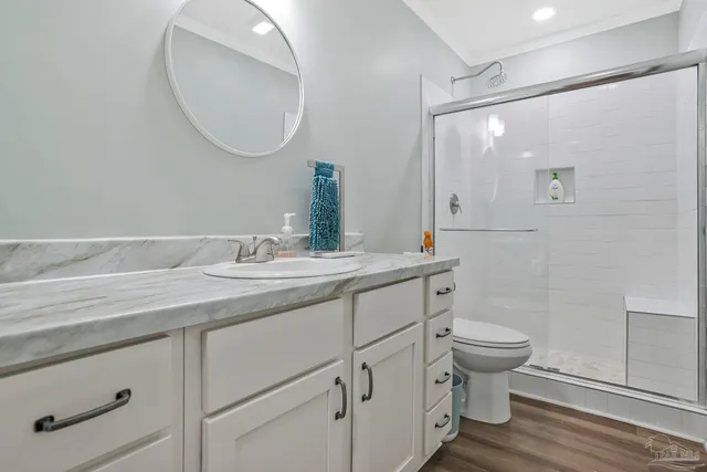 a bathroom with a granite countertop toilet a sink and a mirror