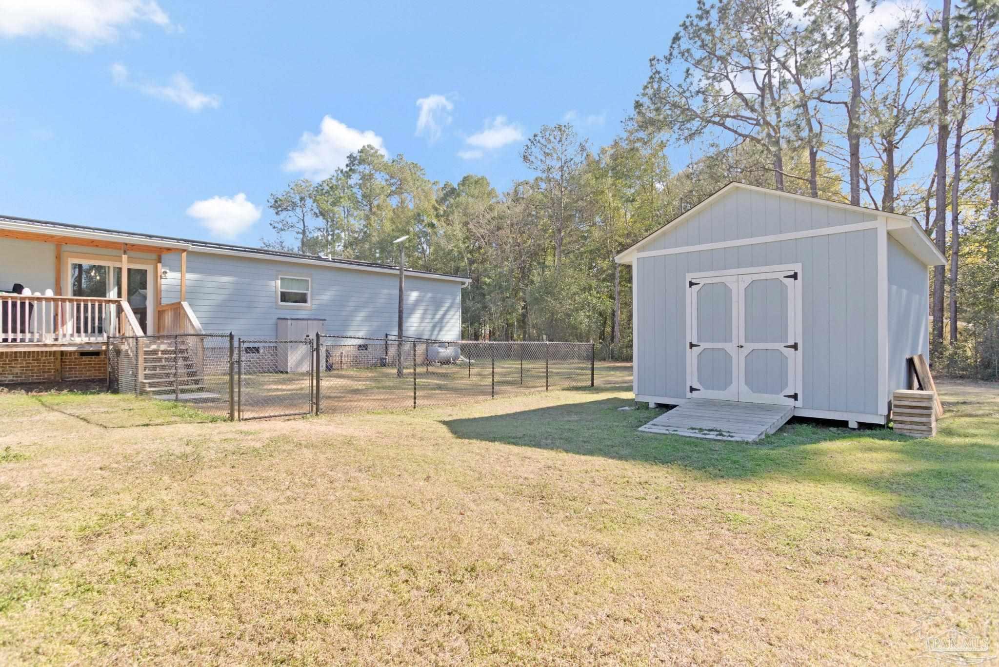 4955 Blue Ribbon Drive Milton, FL 32583 - Photo 33 of 43 a view of a house with backyard and a tree