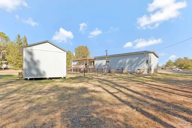 front view of house with deck and a yard