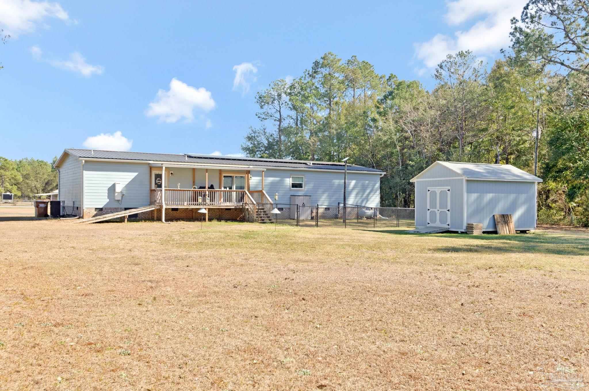 4955 Blue Ribbon Drive Milton, FL 32583 - Photo 35 of 43 a house view with a swimming pool and wooden bench