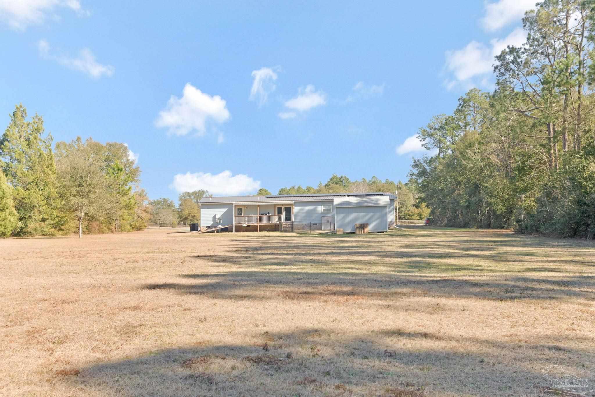 4955 Blue Ribbon Drive Milton, FL 32583 - Photo 37 of 43 a view of a house with a big yard and large trees