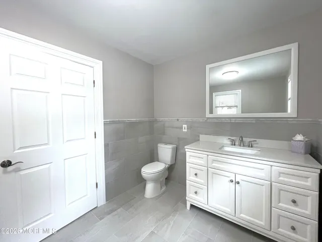 a bathroom with a toilet a sink and a mirror