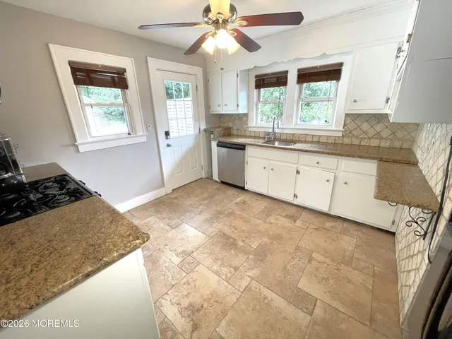 a kitchen with granite countertop a stove a sink and a refrigerator