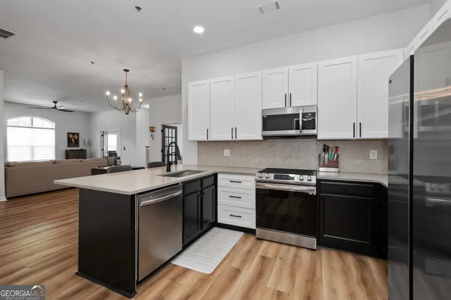 a kitchen with stainless steel appliances granite countertop a stove top oven a sink dishwasher and a refrigerator