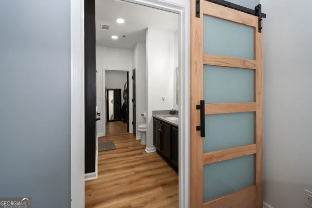 a view of a hallway with wooden floor and staircase