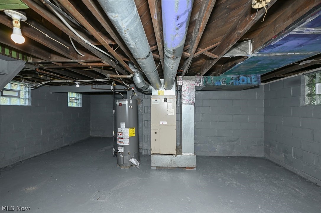 1313 Manchester Road Akron, OH 44307 - Photo 28 of 28 Finished concrete flooring, painted cinder block walls, exposed wood beam ceiling, water heater, and furnace system
