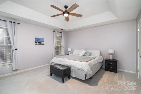 a spacious bedroom with a bed and a ceiling fan