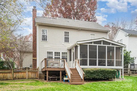 a front view of a house with a yard and potted plants and large tree