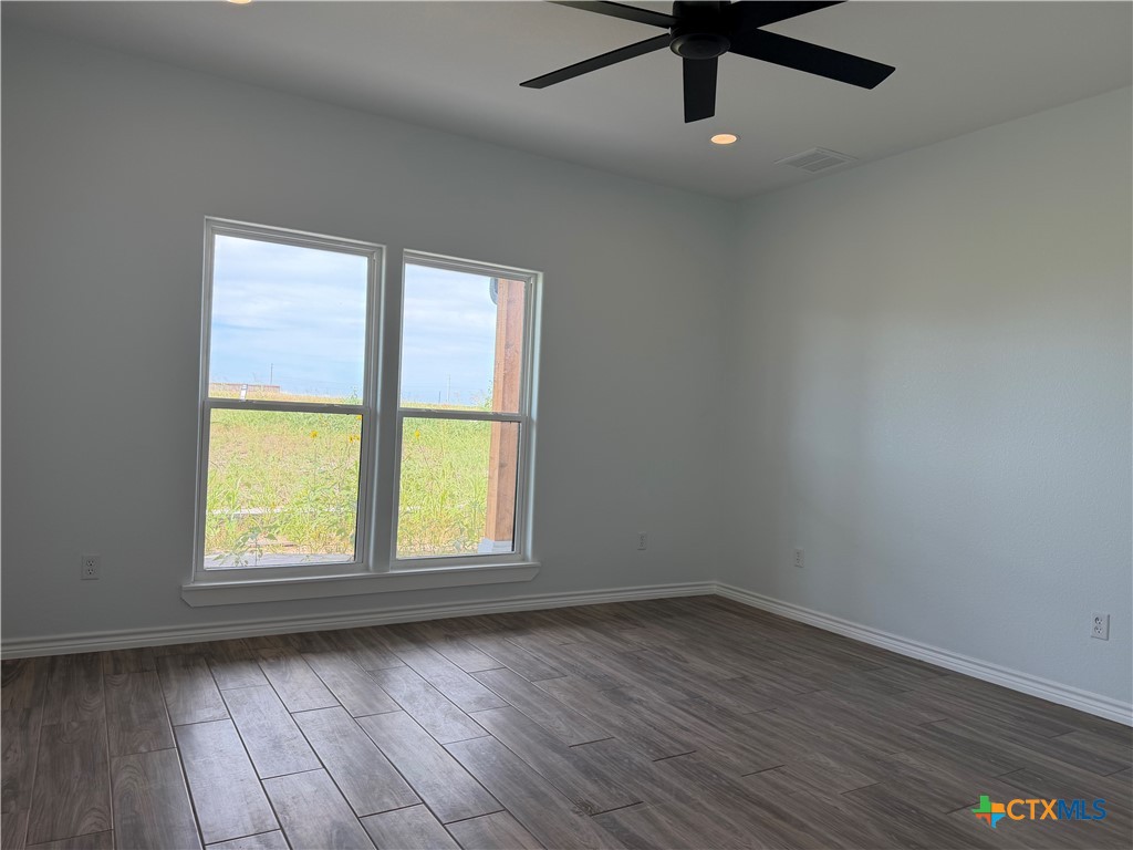 15006 Armstrong Ests Road Salado, TX 76571 - Photo 17 of 29 an empty room with wooden floor fan and windows