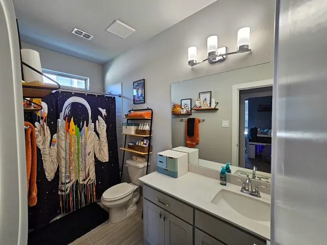 a bathroom with a toilet a sink and a mirror