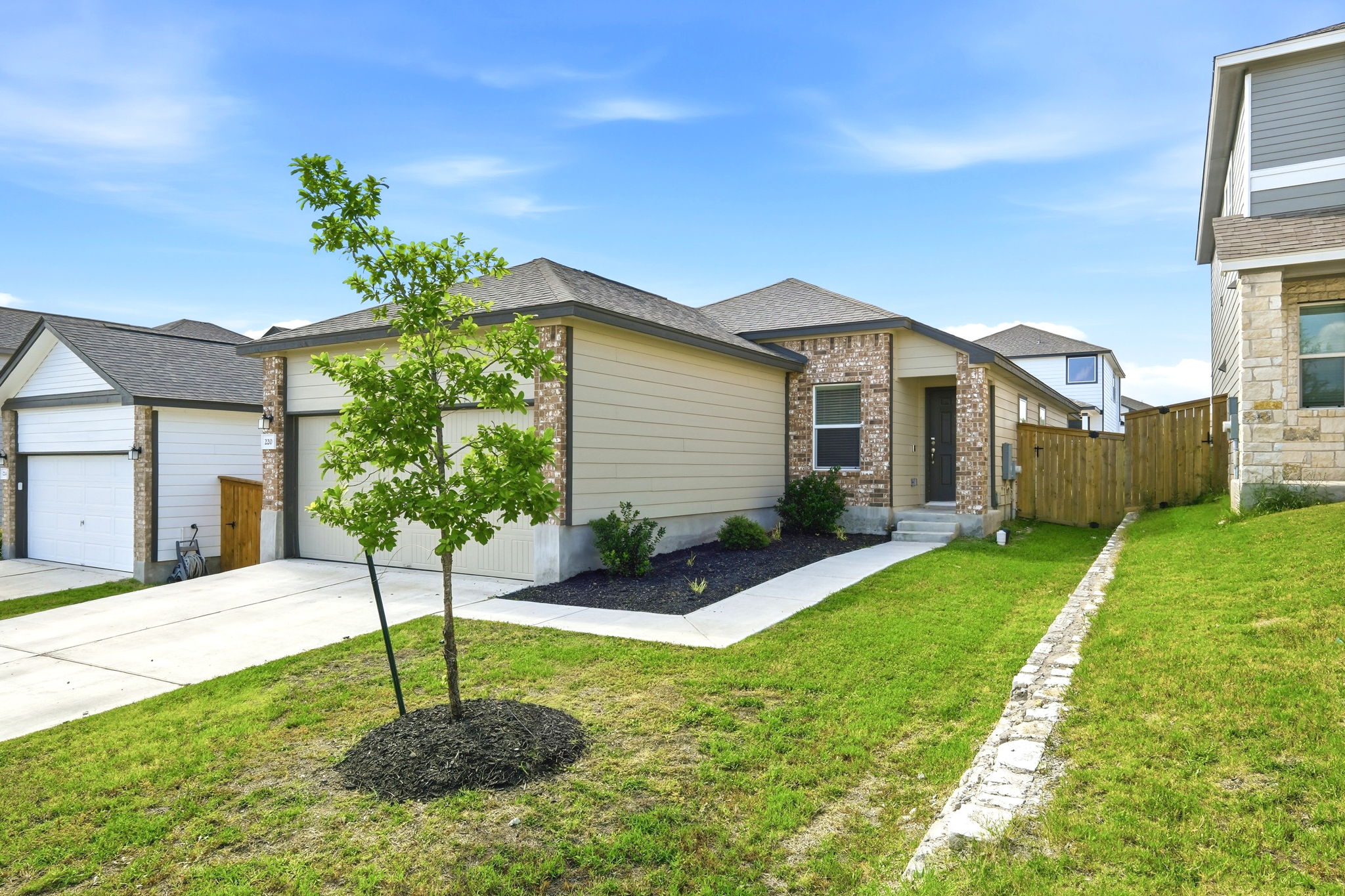 220 Lucky Texan Road Jarrell, TX 76537 - Photo 1 of 19 A newly constructed residence features a mix of brick and siding, complemented by a neatly manicured lawn.