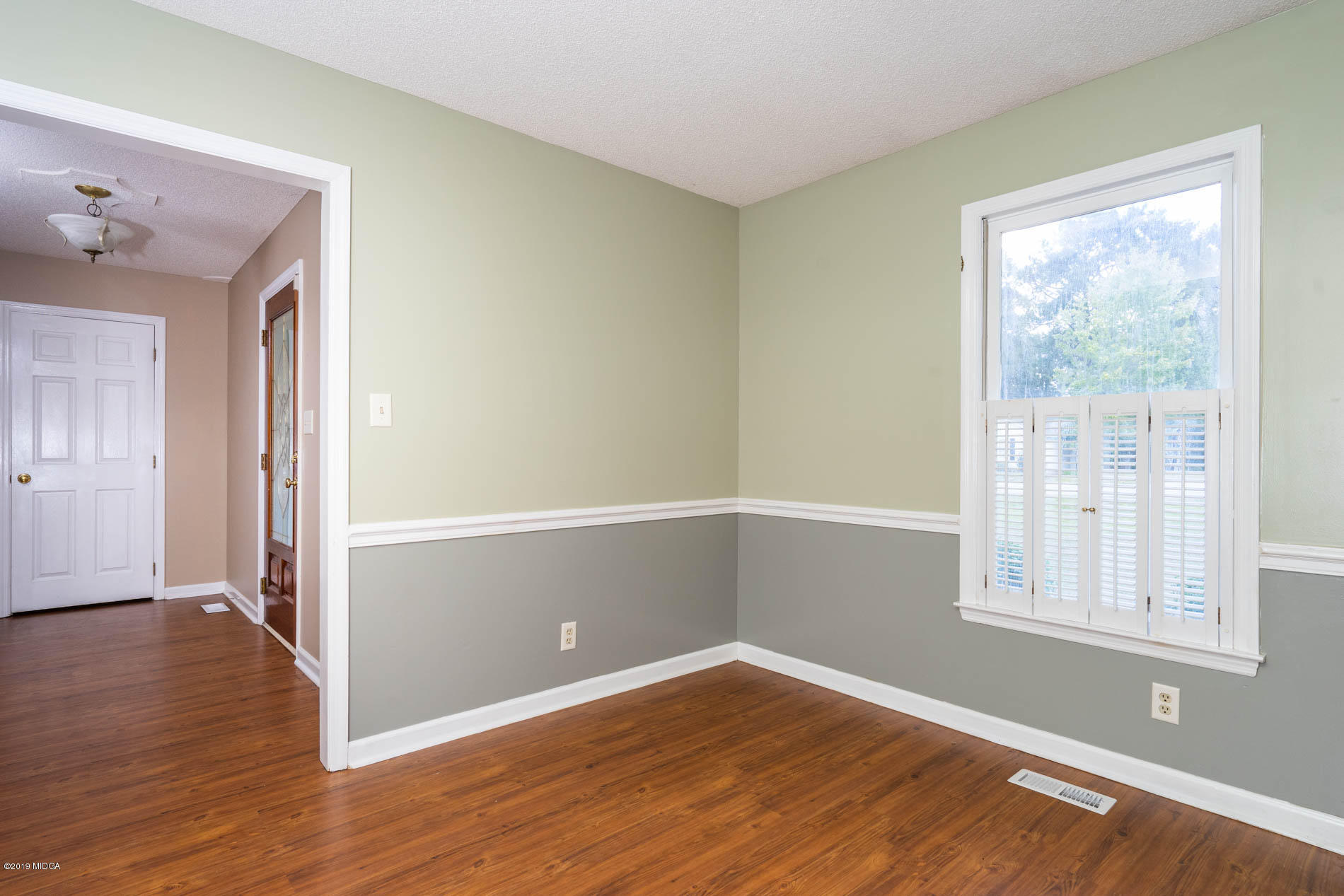 123 Timber Ridge Drive Macon, GA 31216 - Photo 8 of 26 an empty room with wooden floor and windows