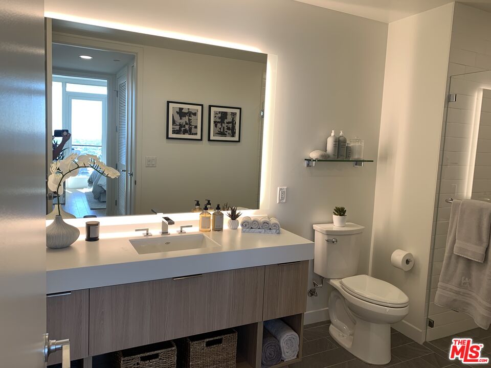 11750 Wilshire Boulevard, Unit 2404 Los Angeles, CA 90025 - Photo 11 of 38 a bathroom with a granite countertop toilet sink and mirror