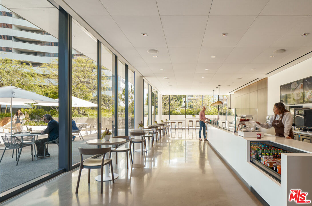 11750 Wilshire Boulevard, Unit 2404 Los Angeles, CA 90025 - Photo 35 of 38 a living room with furniture large windows and view of kitchen