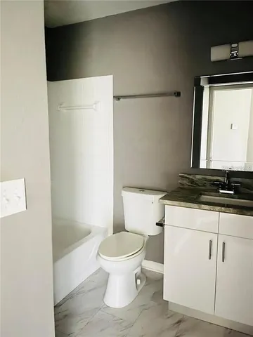 a white toilet sitting next to a bathroom sink