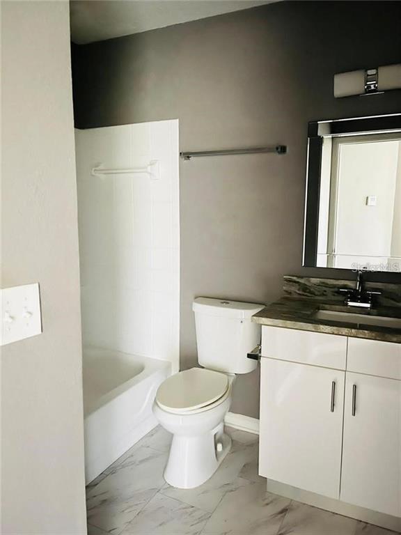 4348 South Kirkman Road, Unit 806 Orlando, FL 32811 - Photo 12 of 29 a white toilet sitting next to a bathroom sink